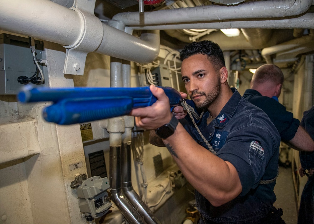 Fire Controlman 2nd Class Dylan Rodriguez, from Menifee, Calif., clears a passageway, with a simtraining firearm, during an anti-terrorism drill