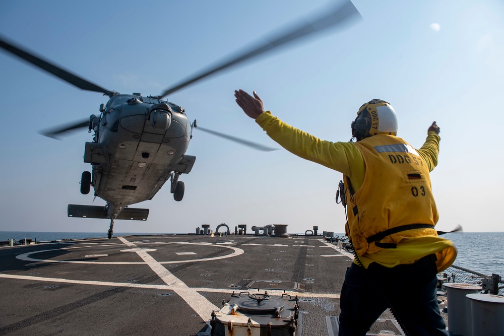 Boatswain’s Mate 3rd Class Tra’shaun Cooper, from Homestead, Texas, directs an MH-60S Sea Hawk helicopter assigned to the “Dragonslayers” of Helicopter Sea Combat Squadron (HSC) 11) to land