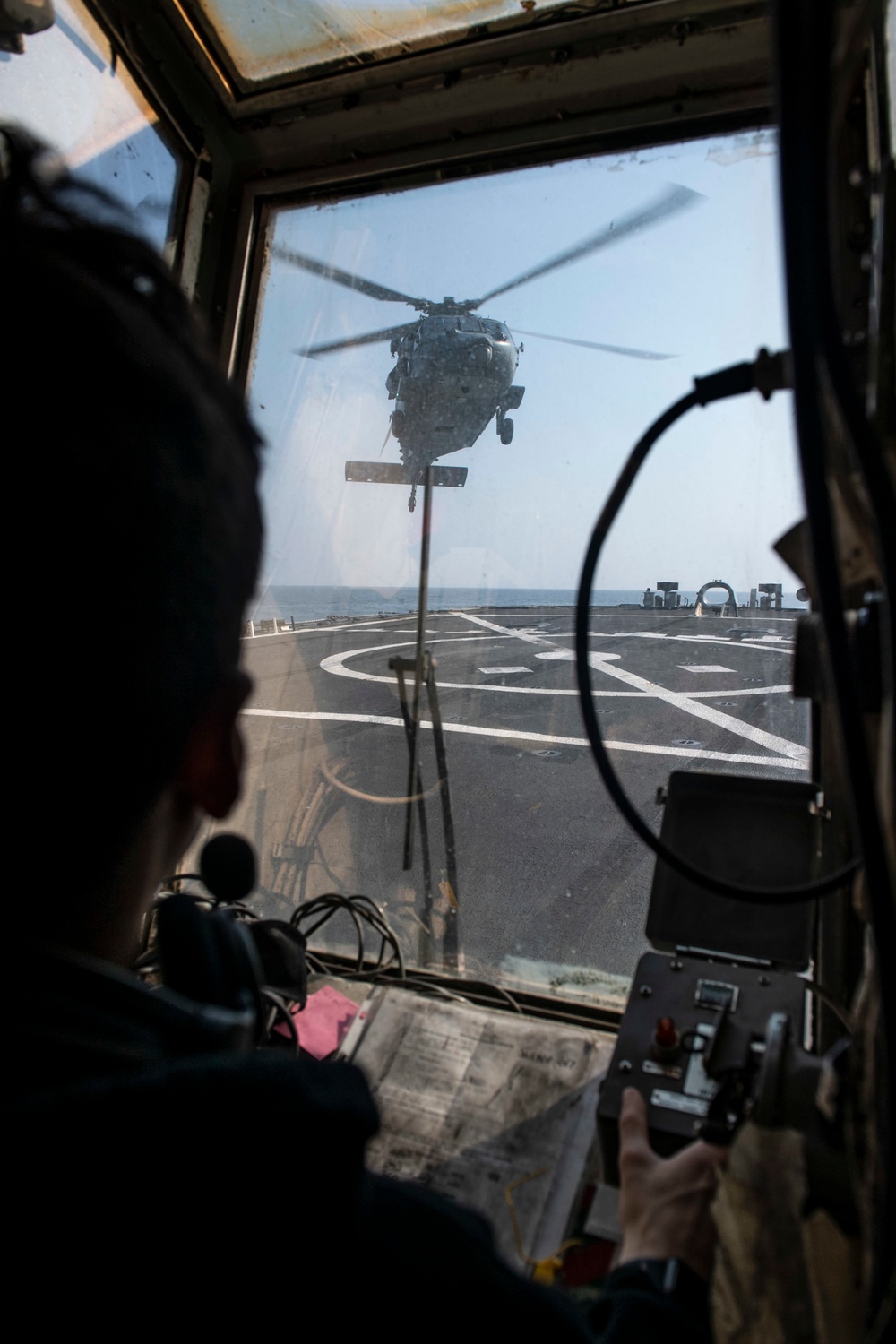 Lt. Joshua Primiano, from Weymouth, Mass., communicates with an MH-60S Sea Hawk helicopter assigned to the “Dragonslayers” of Helicopter Sea Combat Squadron (HSC) 11) in the flight tower