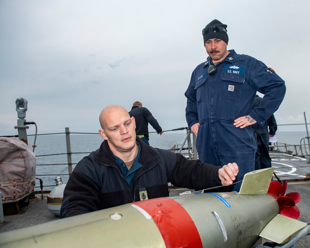 Chief Gunner’s Mate Thomas Lawrence, left, from Cedar City, Utah, and Gunner’s Mate 2nd Class Jay Davis, from Virginia Beach, Va., conduct maintenance on an MK-32 torpedo