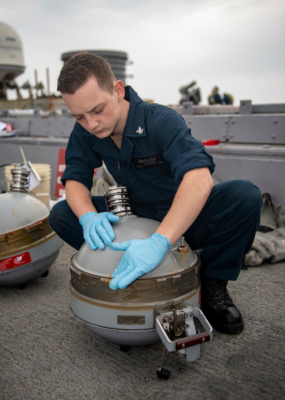 Gunner’s Mate 3rd Class Sebastian Demarais, from Portsmouth, Va., lubricates a Mark-32 surface vessel torpedo tube air flask