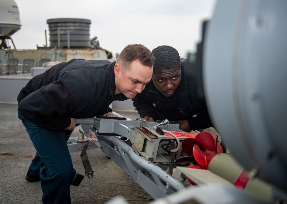 Gunner’s Mate Seaman Tristen Glenn, left, from Lancaster, S.C., and Fire Controlman 1st Class Andre Jackson, right, from Savannah, Ga., load an MK-32 torpedo into a Mark-32 surface vessel torpedo tube