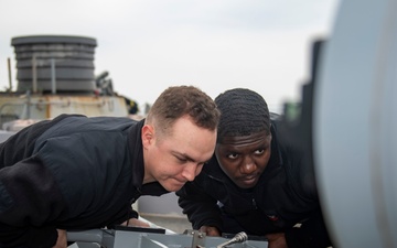 Gunner’s Mate Seaman Tristen Glenn, left, from Lancaster, S.C., and Fire Controlman 1st Class Andre Jackson, right, from Savannah, Ga., load an MK-32 torpedo into a Mark-32 surface vessel torpedo tube