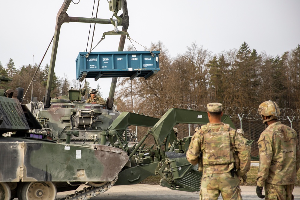 Soldiers of the 10th Brigade  Engineer Battalion, 1st Armored Brigade Combat Team, 3rd Infantry Division lift an inert round for the Mine Clearing Line Charge (MiC-LiC)