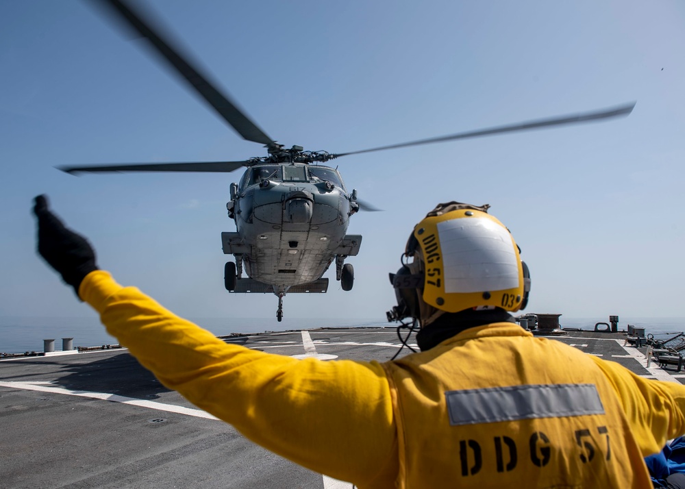 Boatswain’s Mate 3rd Class Isaiah Howard, from Houston, Texas, directs an MH-60S Sea Hawk helicopter