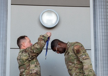 Col. Brian Gunderson, Nevada Air National Guard Director of Staff-Air awards the Maj. Gen. Drennan A. Clark Order of Nevada to Senior Master Sgt. Jordan Clark