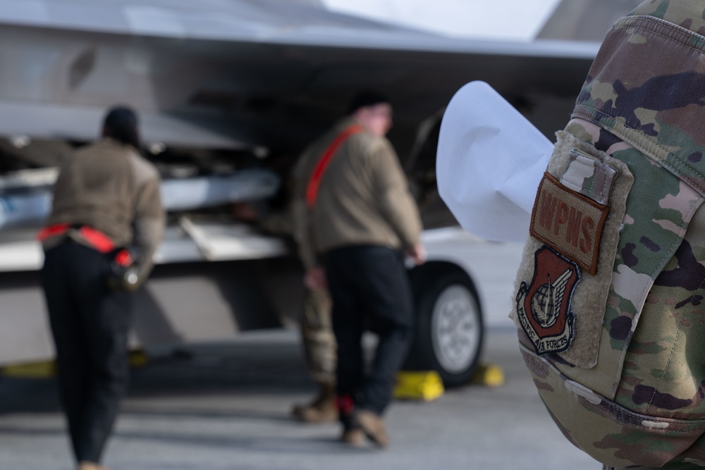 90th weapons load crew members prepare F-22s during Polar Force 22-4