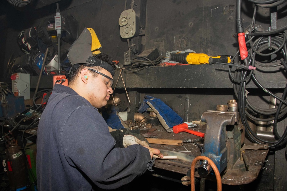 Sailor cleans welds