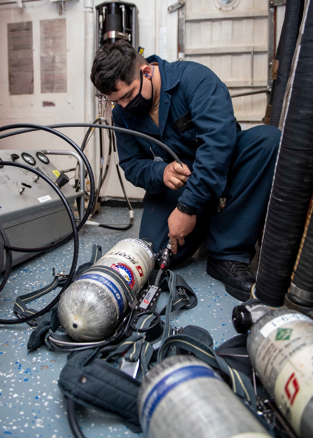 Damage Controlman Fireman Apprentice Michael Resendiz, from Los Angeles, Calif., refills a self-contained breathing apparatus