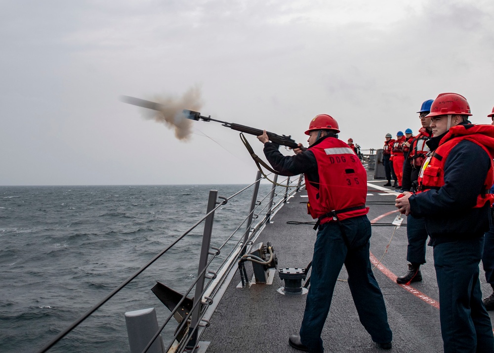 Gunner’s Mate Seaman Tristen Glenn, left, from Lancaster, S.C., assigned to the Arleigh Burke-class guided-missile destroyer USS Mitscher (DDG 57), fires a shot line