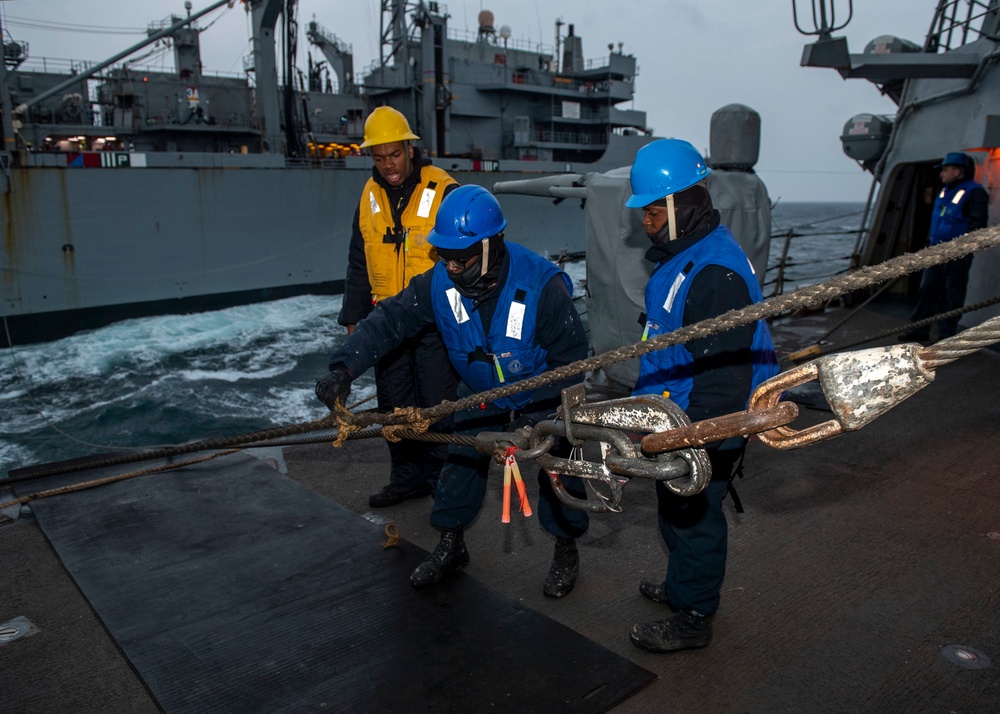 Boatswain’s Mate Seaman Floyd Davis, center, from Fredrick, Md., assigned to the Arleigh Burke-class guided-missile destroyer USS Mitscher (DDG 57), removes line from the high line