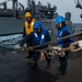 Boatswain’s Mate Seaman Floyd Davis, center, from Fredrick, Md., assigned to the Arleigh Burke-class guided-missile destroyer USS Mitscher (DDG 57), removes line from the high line