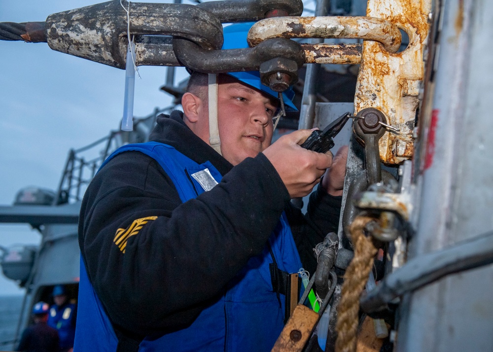 Professional Apprenticeship Career Tract (PACT) Seaman Cullen Patterson, from Cherry Hill, N.J., assigned to the Arleigh Burke-class guided-missile destroyer USS Mitscher (DDG 57), removes a pin from a pad eye winch