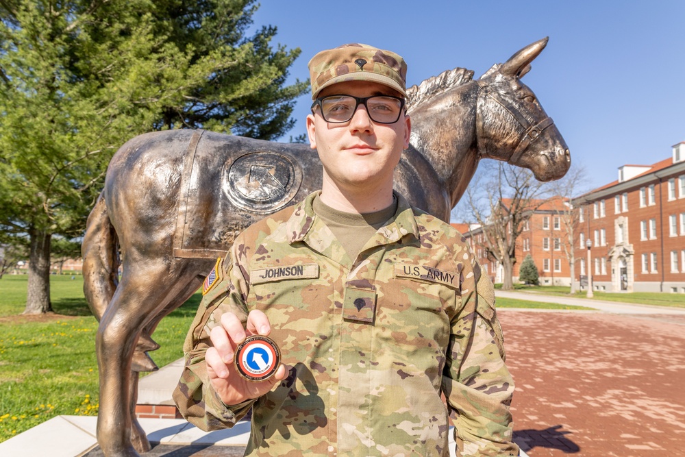 Spc. Logan Johnson shows his 1st TSC commanding general's coin