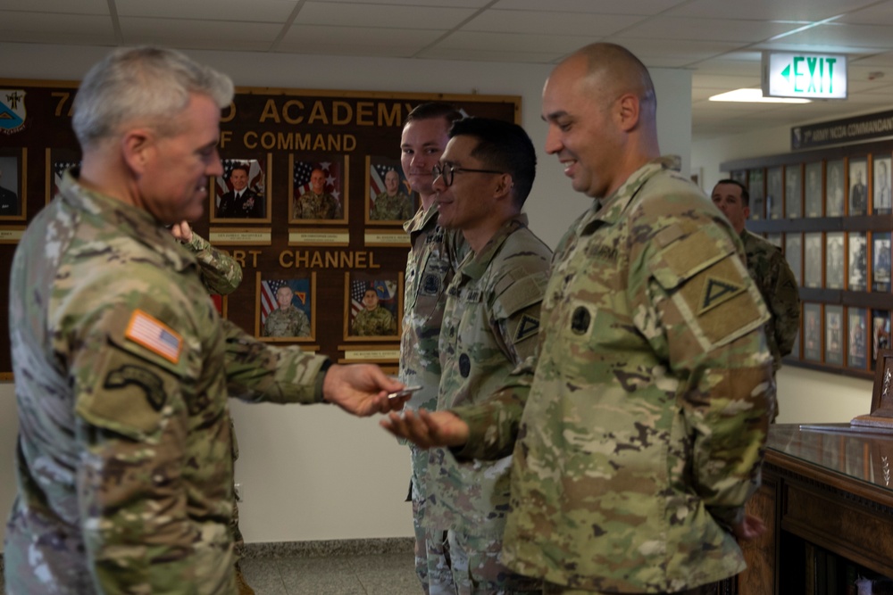 U.S. Army Europe and Africa’s Command Sgt. Maj. Jeremiah E. Inman gives coins