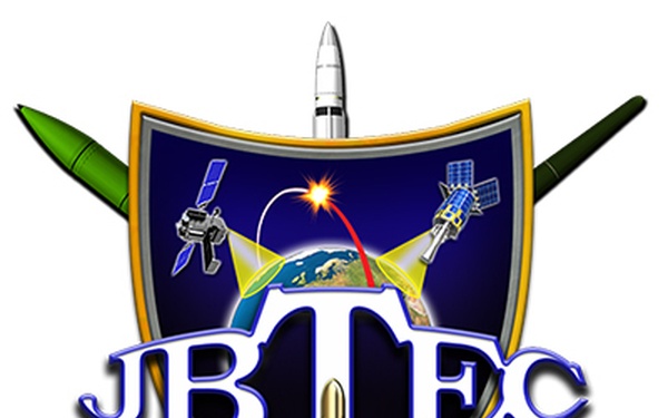 This is a military/defense organizational emblem for 'JBTEC' featuring a heraldic shield design with space and missile defense imagery. The logo incorporates satellites, a globe, laser/energy beams, and various missile and rocket systems arranged around a central shield. The design suggests a joint ballistic or space-based technology and engineering command or center.