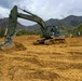 NMCB THREE Seabees operates a John Deere 210G Excavator to create a fighting position in the JLTV Operation Course.
