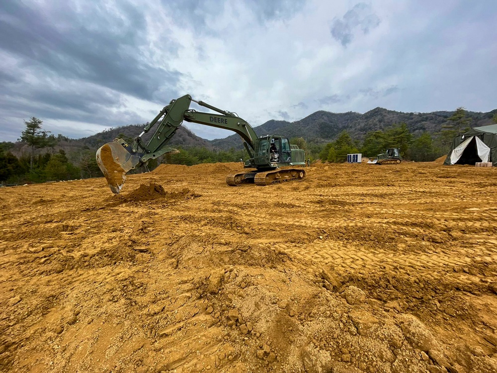 NMCB THREE Seabees operates a John Deere 210G Excavator to create fighting positions in the JLTV Operation Course