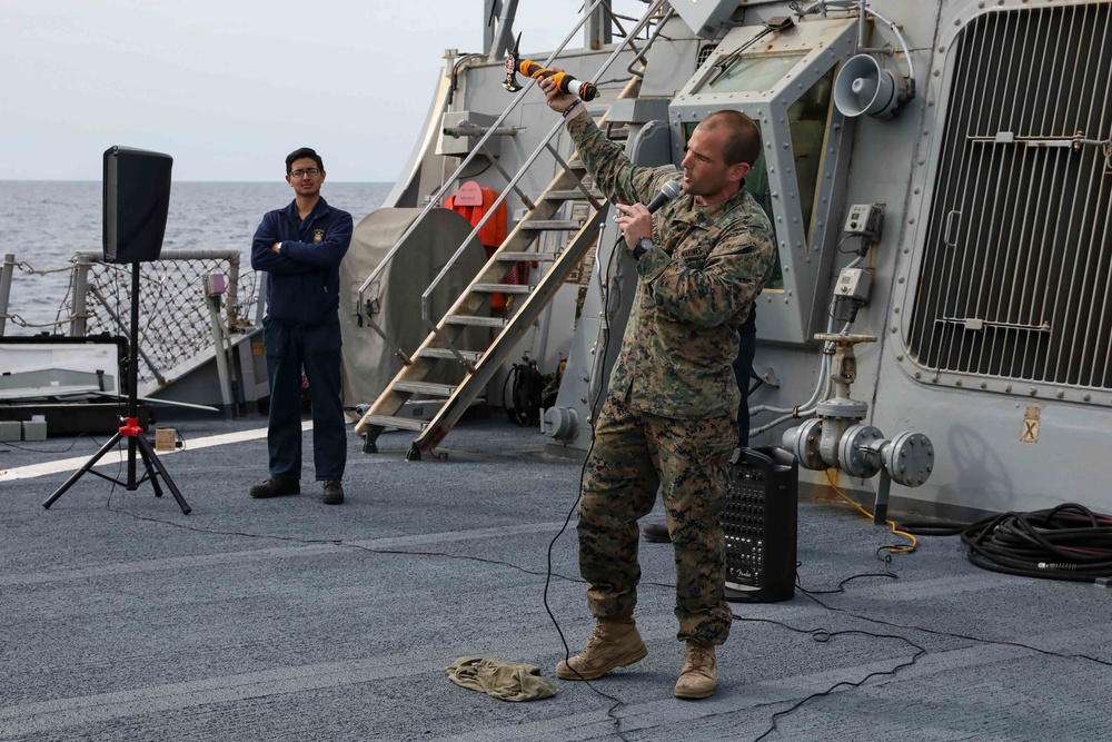 U.S. Marines onboard USS Ross present a parting gift to crew