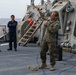 U.S. Marines onboard USS Ross present a parting gift to crew