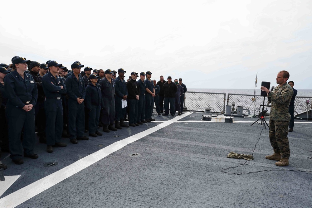 U.S. Marines onboard USS Ross present a parting gift to crew