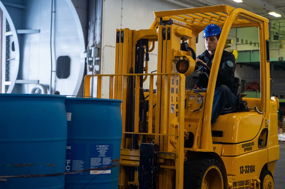 Sailors Move Supplies In The Hangar Bay Aboard USS Carl Vinson (CVN 70)