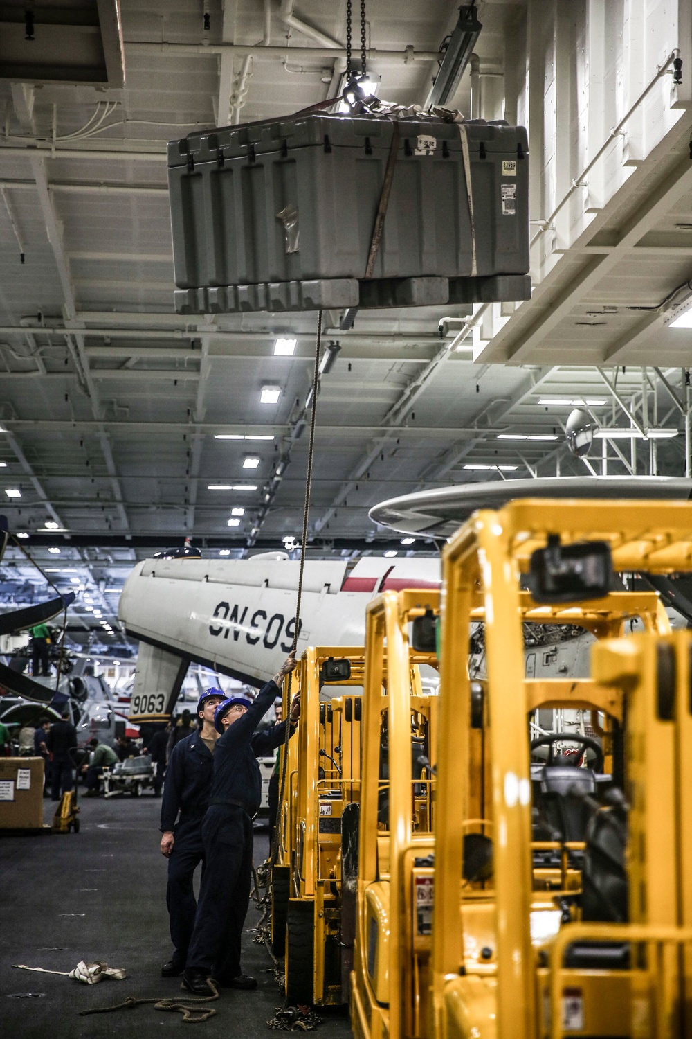 Abraham Lincoln Sailors lift heavy equipment