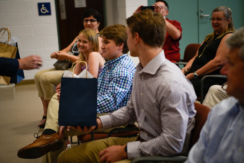 Col. Kwasny presents her children with gifts during her retirement ceremony