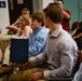 Col. Kwasny presents her children with gifts during her retirement ceremony