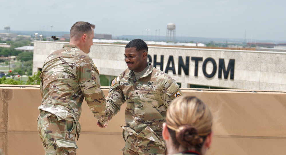 Fort Hood Soldier reenlists on top of the III Corps Headquarters