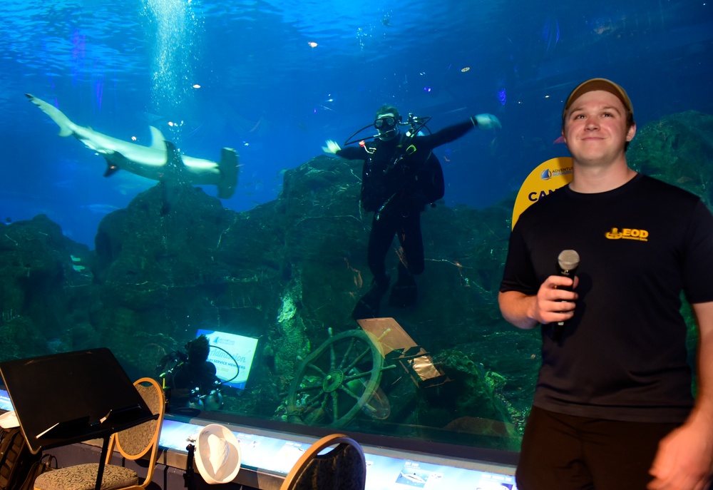 Navy Explosive Ordnance Disposal Technicians demonstrate dive skills at aquarium.