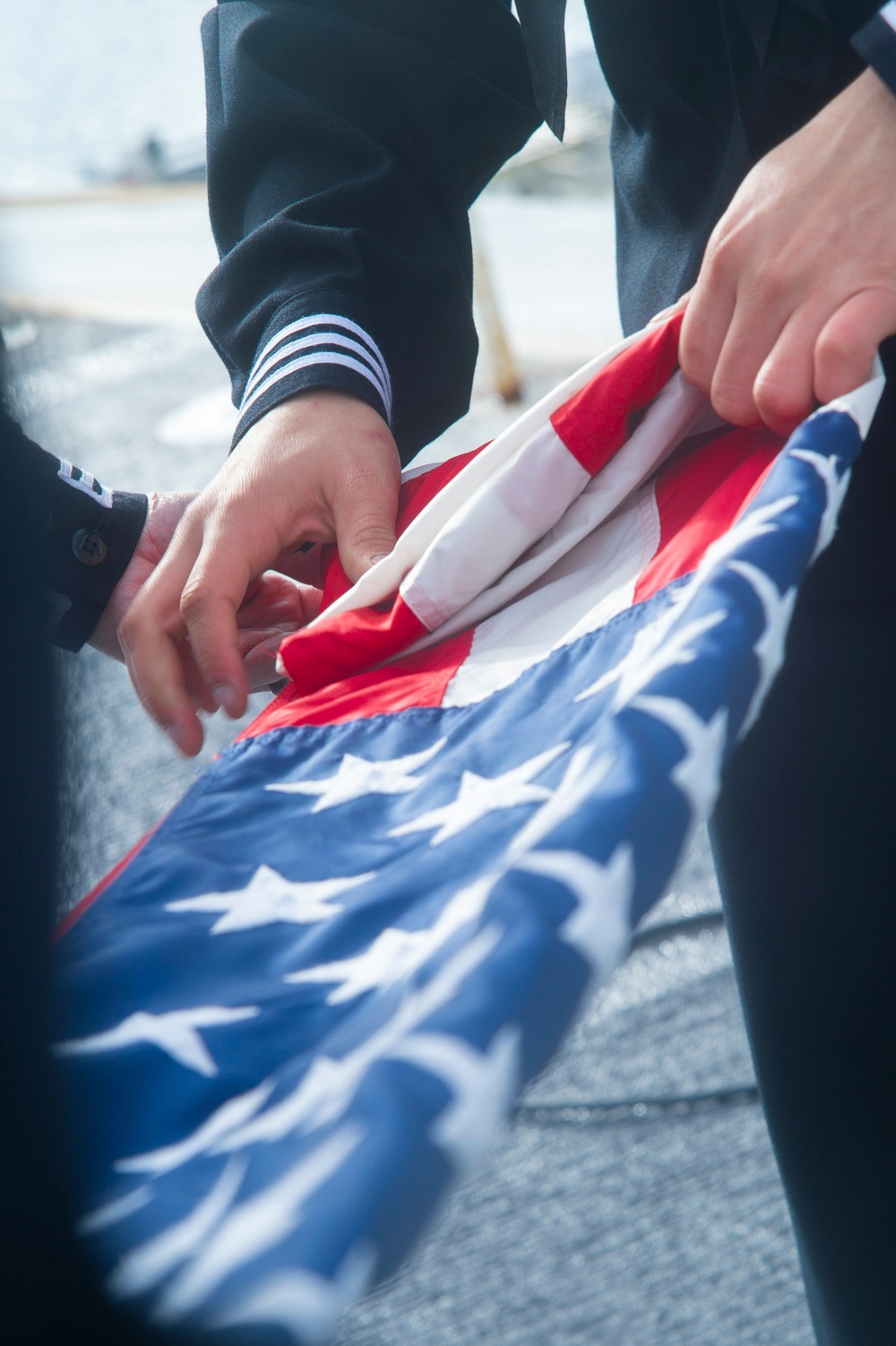 Sailors Fold The National Ensign