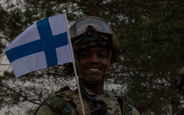 U.S. Army Sgt. waves Finnish flag during Exercise Arrow 22