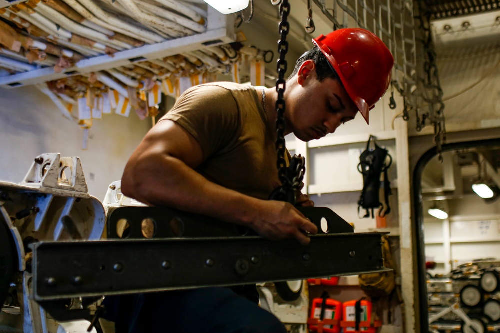Abraham Lincoln Sailors move ordnance equipment