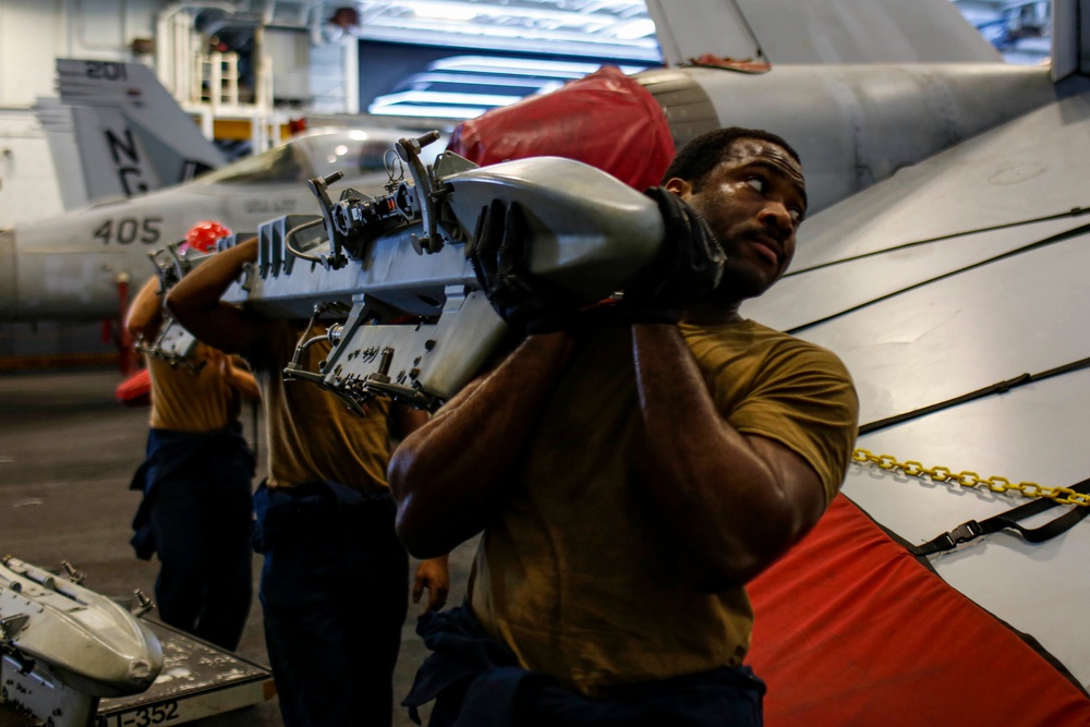 Abraham Lincoln Sailors move ordnance equipment