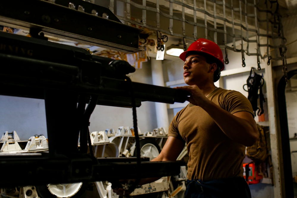 Abraham Lincoln Sailors move ordnance equipment