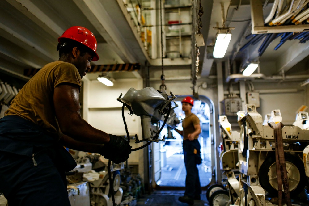 Abraham Lincoln Sailors move ordnance equipment