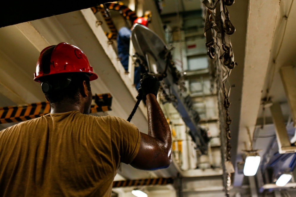 Abraham Lincoln Sailors move ordnance equipment