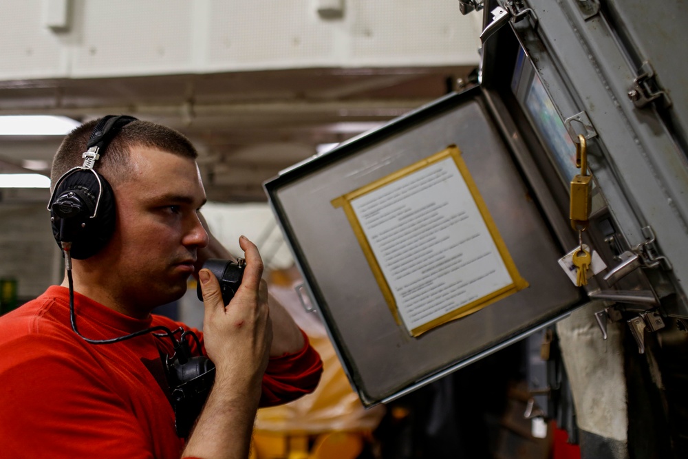Abraham Lincoln Sailors move ordnance equipment