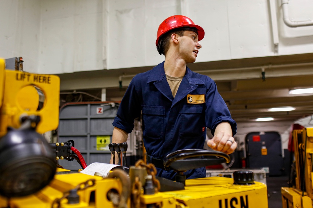 Abraham Lincoln Sailors move ordnance equipment