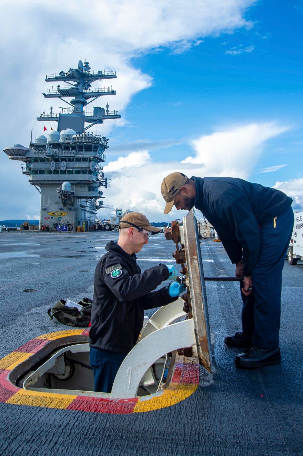 Sailors Conduct Maintenance On The Flight Deck