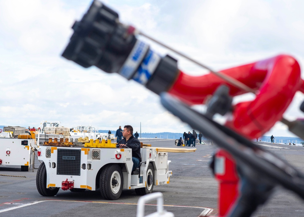 Sailor Taxis An Aircraft Tractor On The Flight Deck