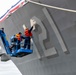 Sailors Paint the Hull Number of the USS Frank E. Petersen for Her Commissioning
