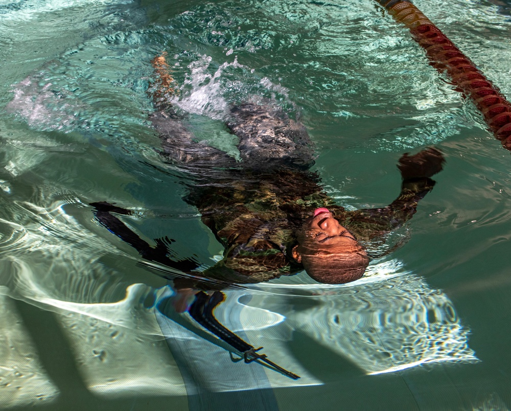 Pfc. Jordan Watson swims with his weapon