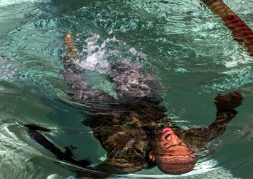 Pfc. Jordan Watson swims with his weapon