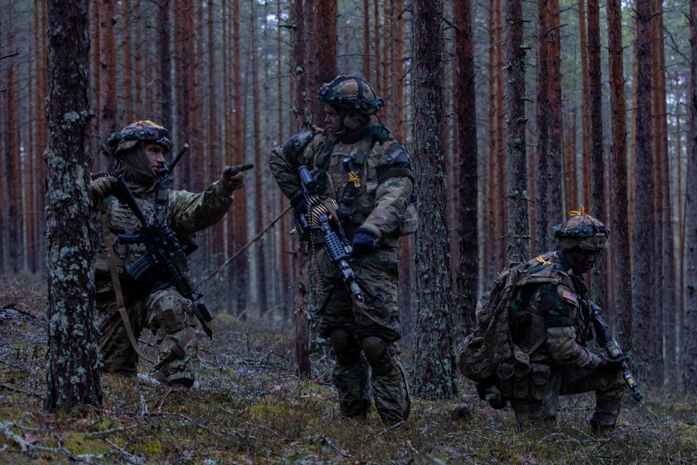 U.S. Army Staff Sgt. Devon Penrod, left, assigned to 4th Squadron, 2d Cavalry Regiment, show his Soldiers Spc. Caden Sangals, center, and Spc. David Oppenheim, right, what their sectors of fire are during Exercise Arrow 22