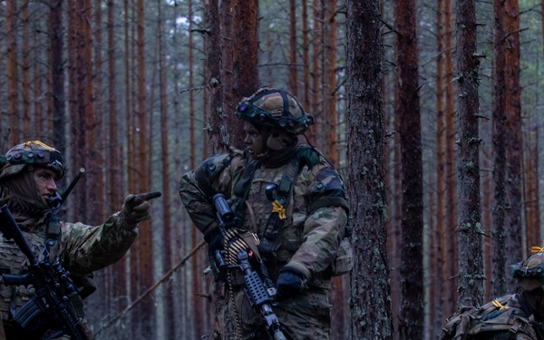 U.S. Army Staff Sgt. Devon Penrod, left, assigned to 4th Squadron, 2d Cavalry Regiment, show his Soldiers Spc. Caden Sangals, center, and Spc. David Oppenheim, right, what their sectors of fire are during Exercise Arrow 22