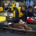 Sailor Applies A Wrap To Arm Of Casualty