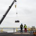 Civilian personnel transport materials onto the flight deck of USS Carl Vinson (CVN70)
