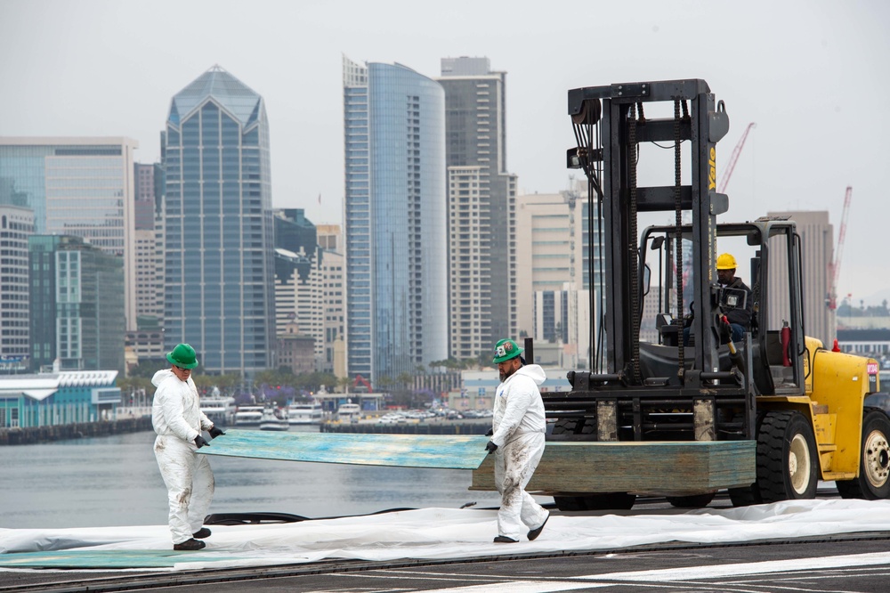 Civilian personnel place pallets on the flight deck of USS Carl Vinson(CVN70)